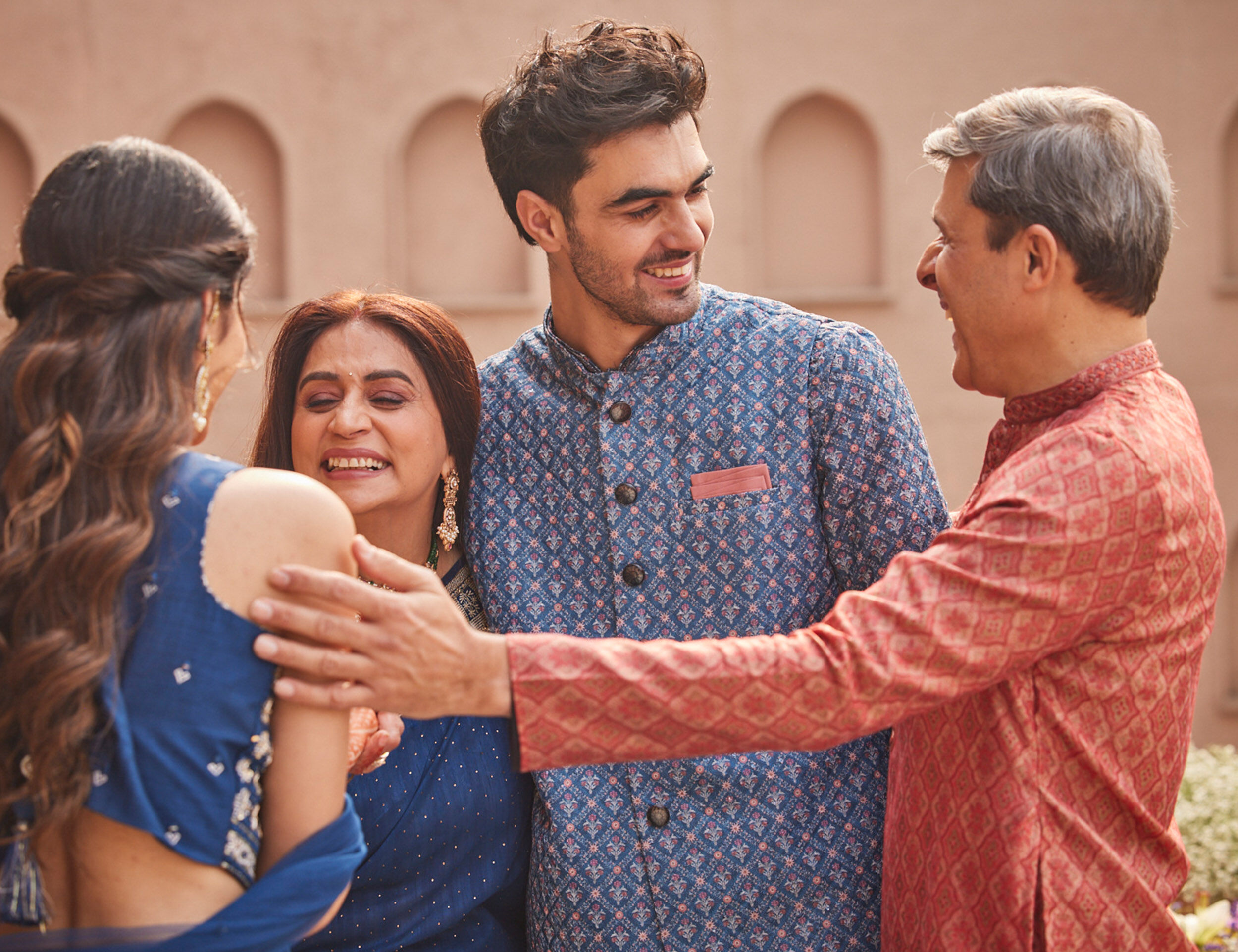 A group of friends and family laughing together, celebrating the lively and joyful atmosphere of an Indian Roka ceremony.